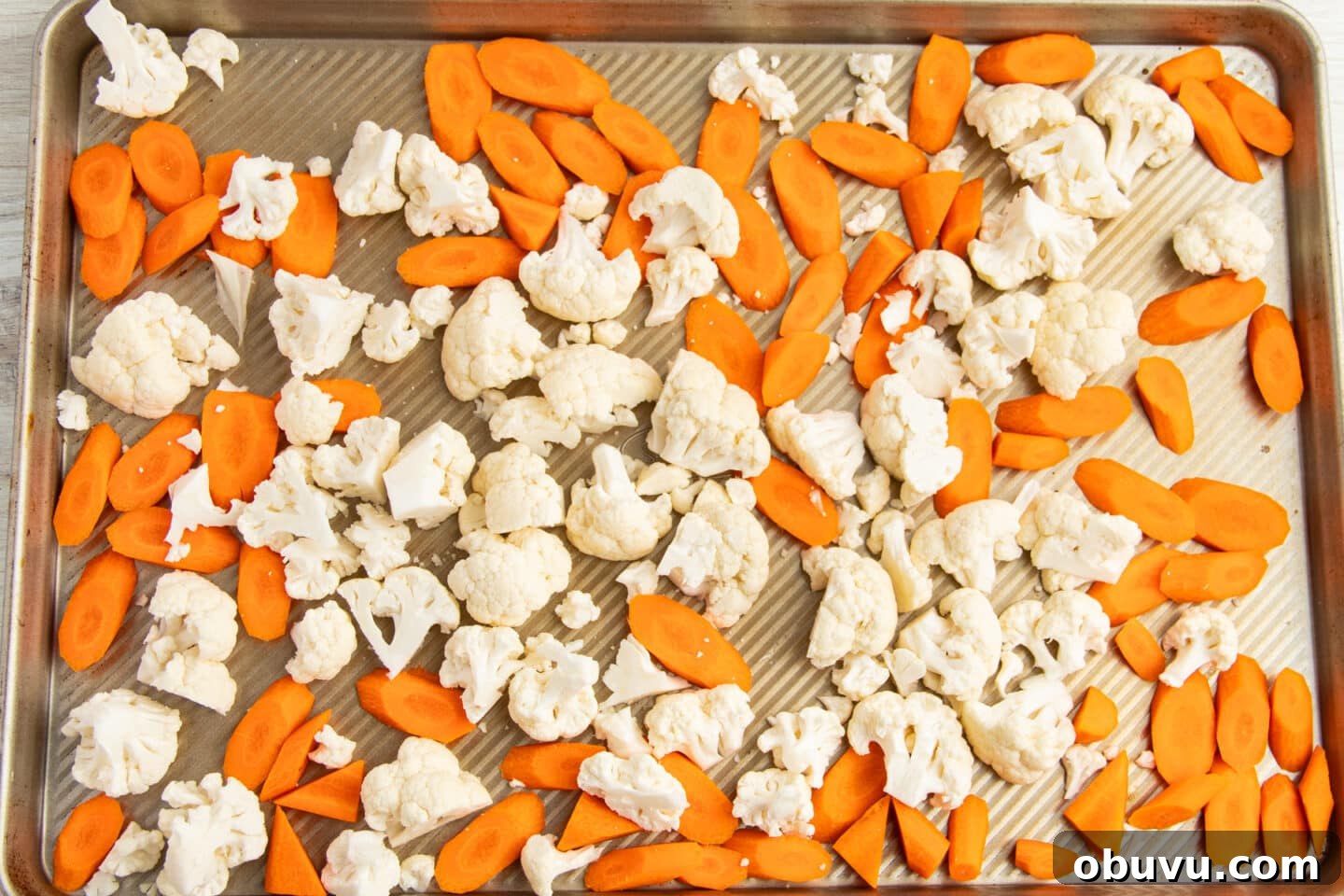Roasted Carrots and Cauliflower in Cheesy Garlic Crust 6 This is a picture of a baking tray with raw carrots and cauliflower.