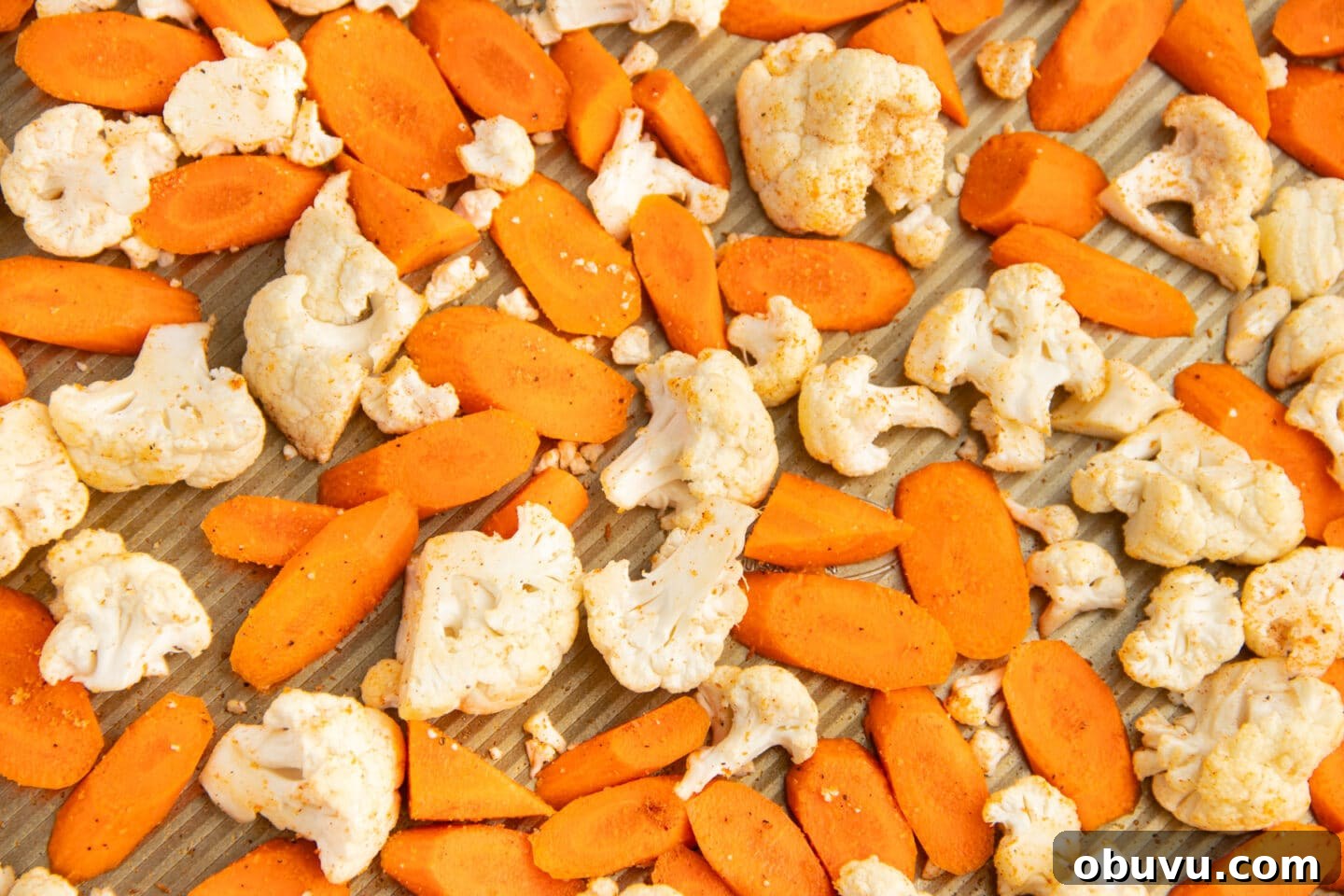 Roasted Carrots and Cauliflower in Cheesy Garlic Crust 7 This is a picture of a baking tray with seasoned carrots and cauliflower.
