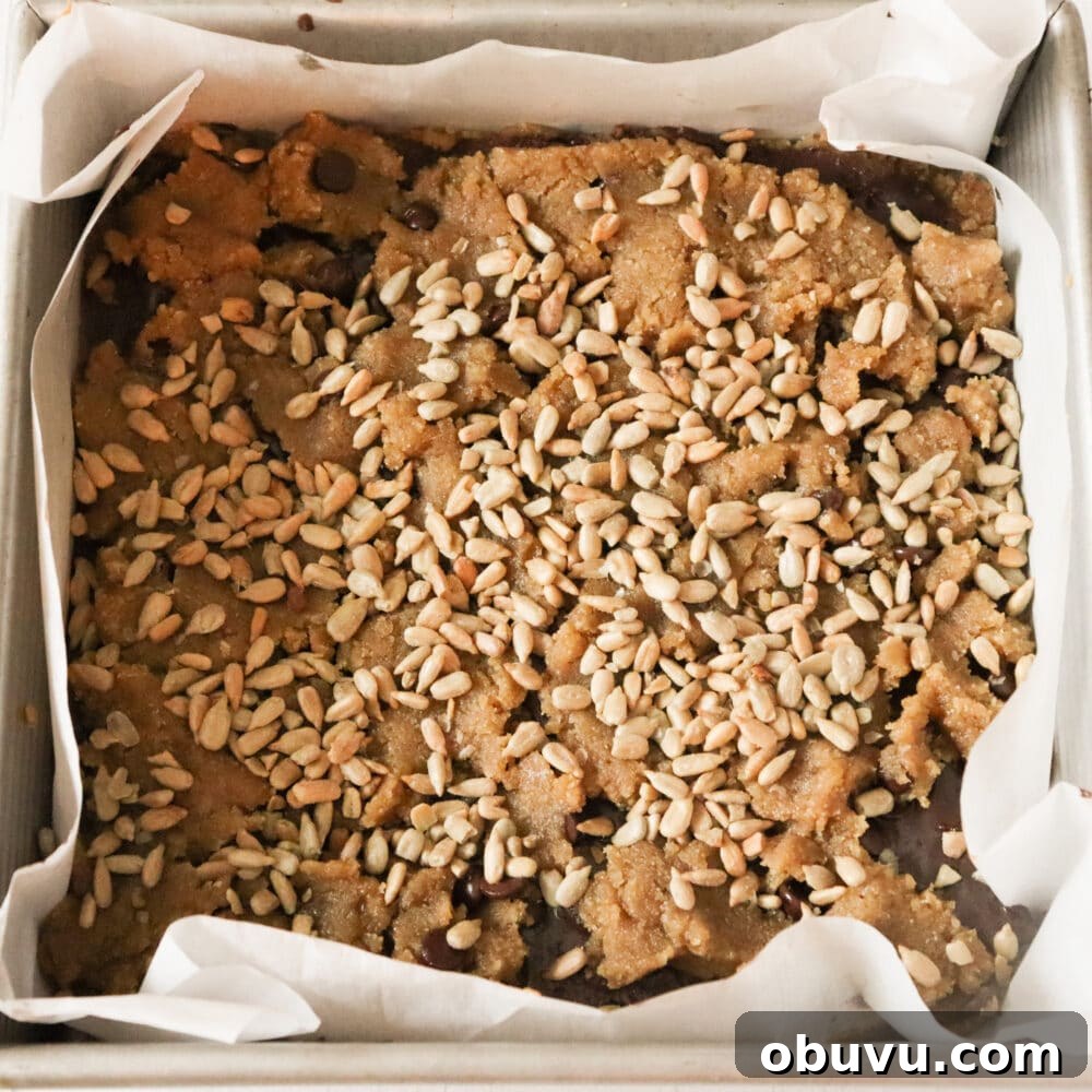 cookie bars assembled and ready for oven sunflower seeds on top
