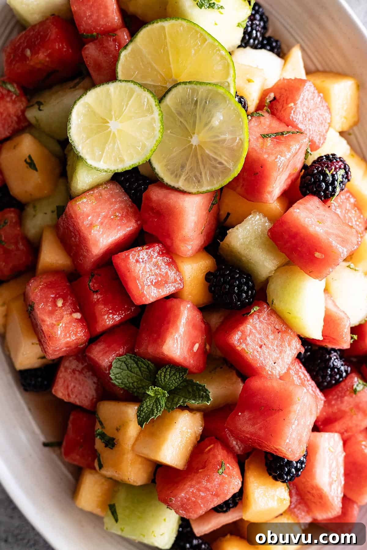 Mojito Fruit Salad Recipe: Refreshing Mint-Lime Fruit Bowl 5 Overhead view of salad on a cream serving platter.
