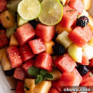 Mojito Fruit Salad Recipe: Refreshing Mint-Lime Fruit Bowl 7 Overhead view of salad on a cream serving platter.