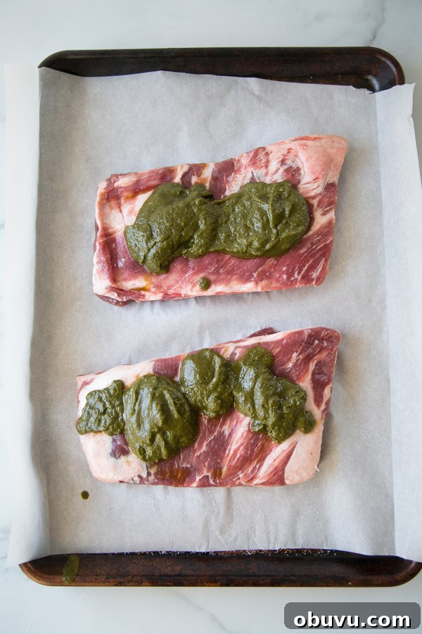 Slow-Roasted Baby Back Ribs in 2½ Hours: Tender, Fall-Off-Bone 6 Baby Back Ribs on a sheet pan before the oven with green chile bbq sauce on top