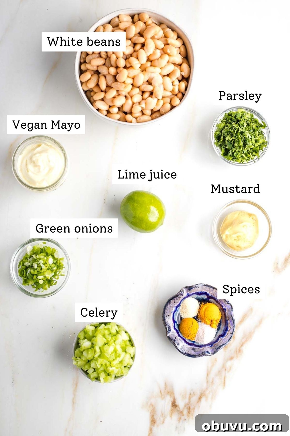 Crispy Vegan Chicken Salad with Creamy Herb Dressing 3 Labeled ingredients: white beans, chopped parsley, vegan mayo, lime, mustard, sliced scallions and celery, spices.