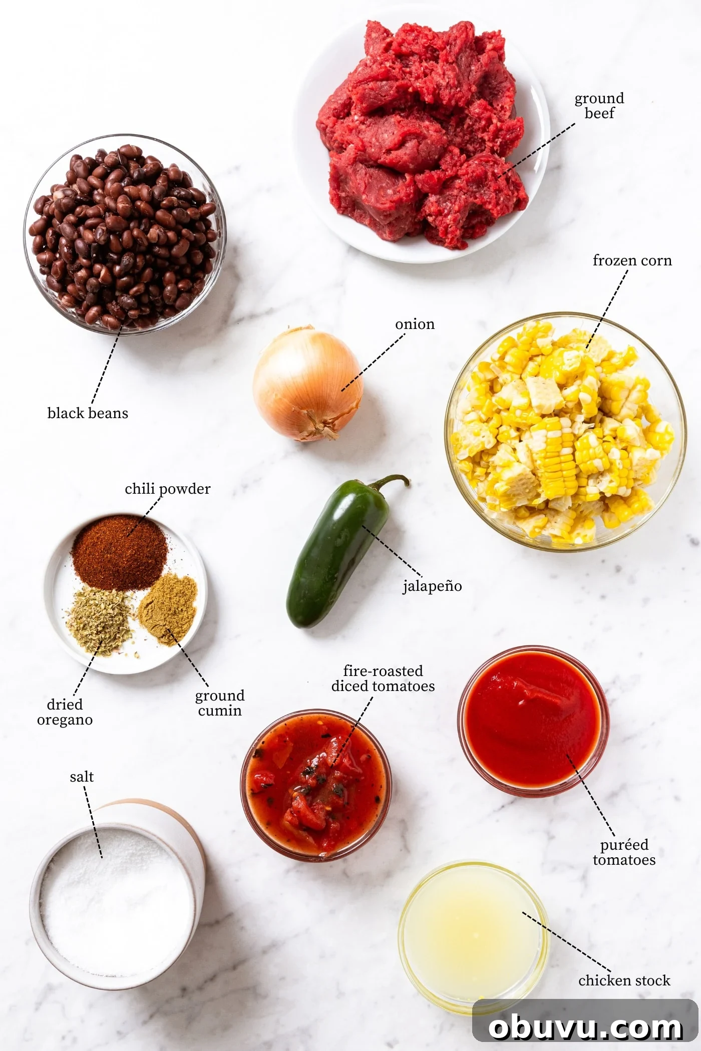 Quick Homemade Taco Soup Recipe for Cozy Weeknight Dinners 4 White marble surface filled with all ingredients needed to make taco soup including ground beef, black beans, frozen corn, tomatoes, spices, and more.