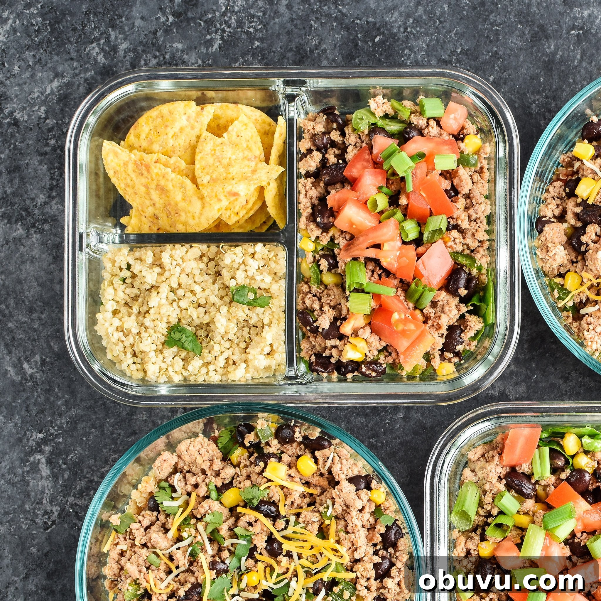 Hot and Cold Turkey Taco Meal Prep with Video Tutorial 3 Meal prepped lunches viewed from above for Hot & Cold Turkey Taco Meal Prep; two taco salads with quinoa and chips on the side and two taco bowls with tomato and green chili quinoa.