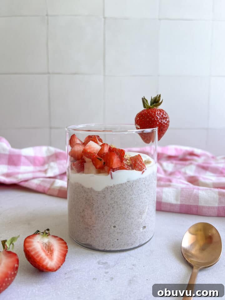 Blended Strawberry Cheesecake Chia Pudding Recipe 2 Glass jar containing blended strawberry cheesecake chia pudding, topped with yogurt, strawberries, and graham cracker crumbs