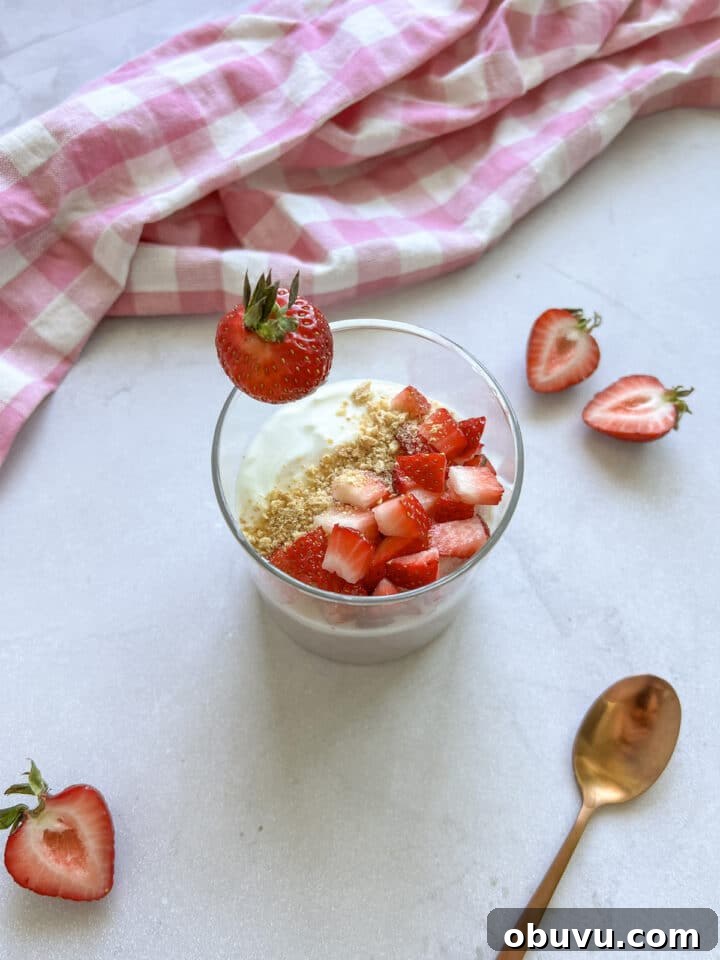 Blended Strawberry Cheesecake Chia Pudding Recipe 3 Glass jar containing strawberry cheesecake chia pudding with fresh strawberries and graham cracker crumbs