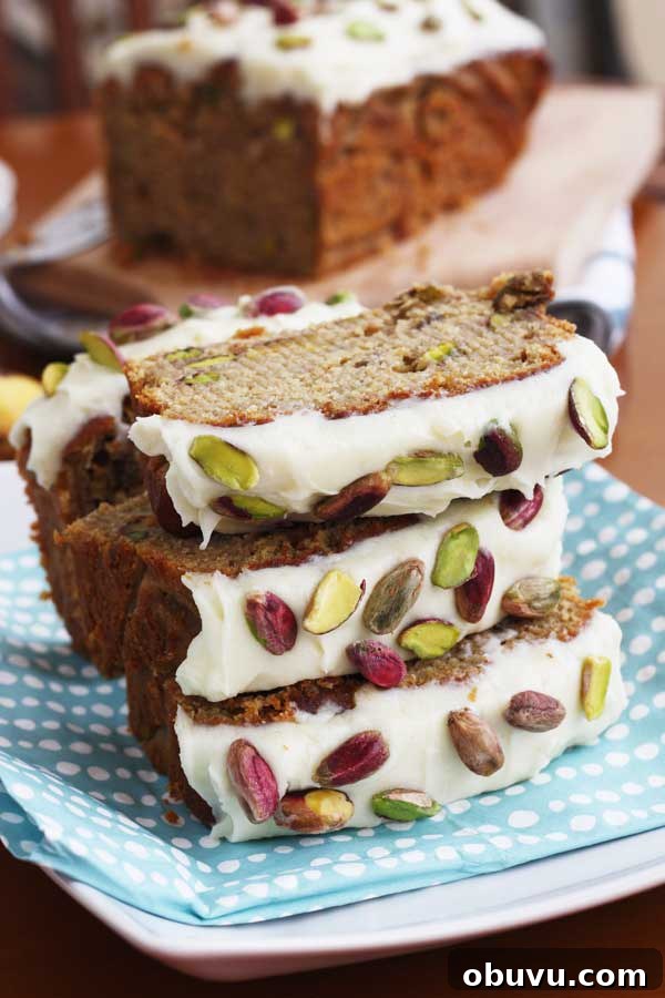 Banana Pistachio Cake with White Chocolate Cream Cheese Frosting 2 Pieces of banana and pistachio loaf stacked on a blue spotty cloth