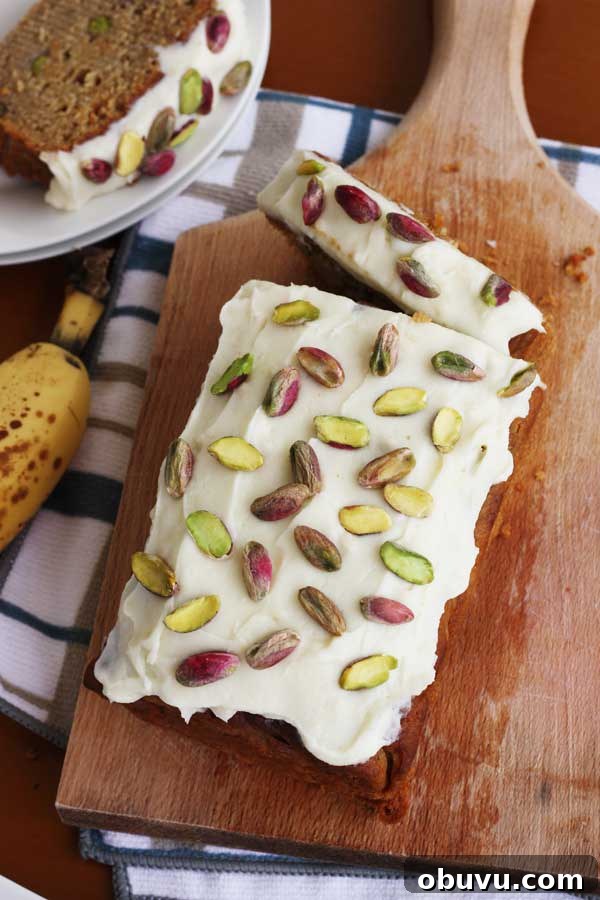 Banana Pistachio Cake with White Chocolate Cream Cheese Frosting 3 banana pistachio loaf with white chocolate cream cheese frosting from above on a wooden board