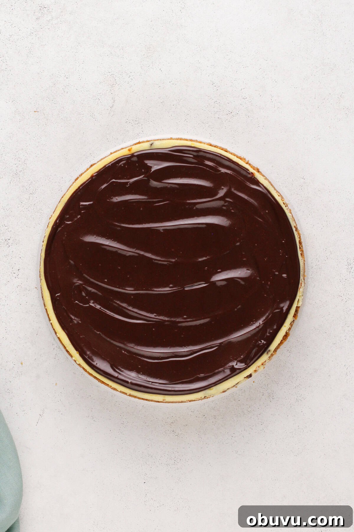 Chocolate ganache spread over cooled chocolate chip cheesecake.