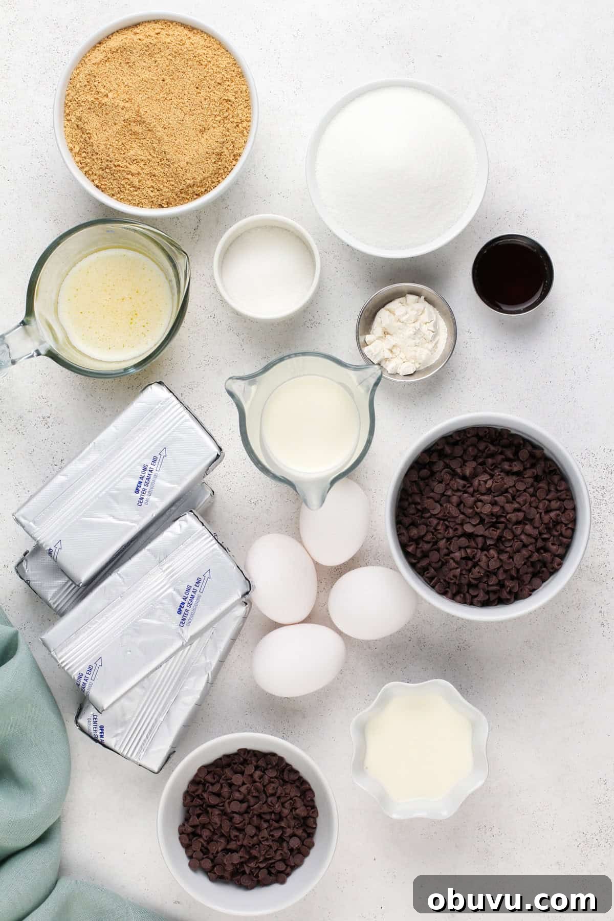 Ingredients for chocolate chip cheesecake arranged on a countertop.