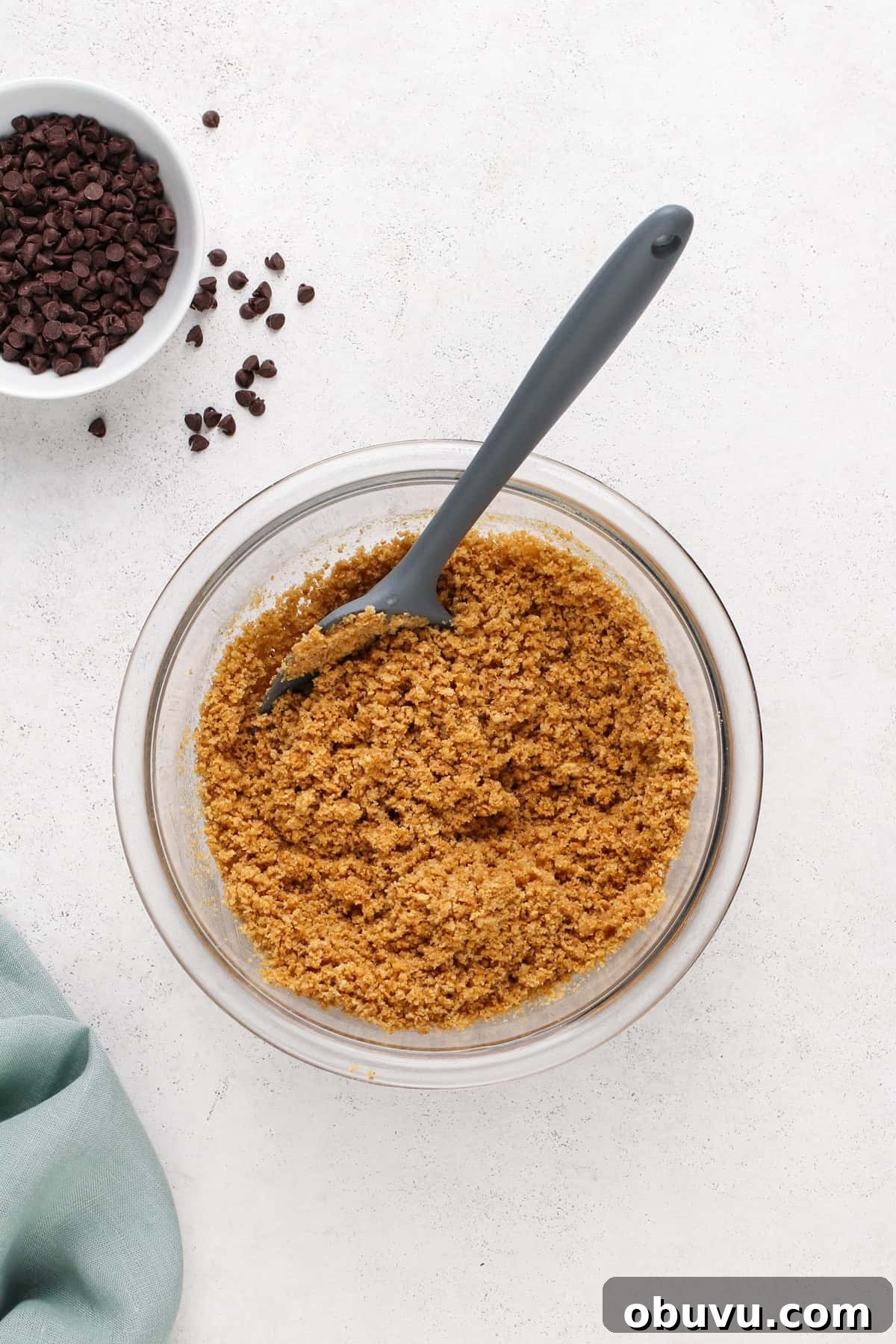 Graham cracker crust mixture in a glass bowl.
