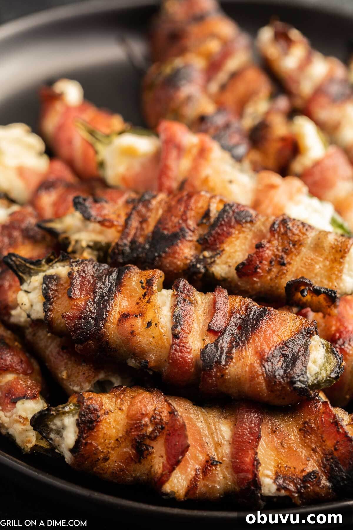 Smoky Grilled Jalapeño Poppers with Cream Cheese Filling 10 Close up image of bacon wrapped jalapeno poppers on a plate