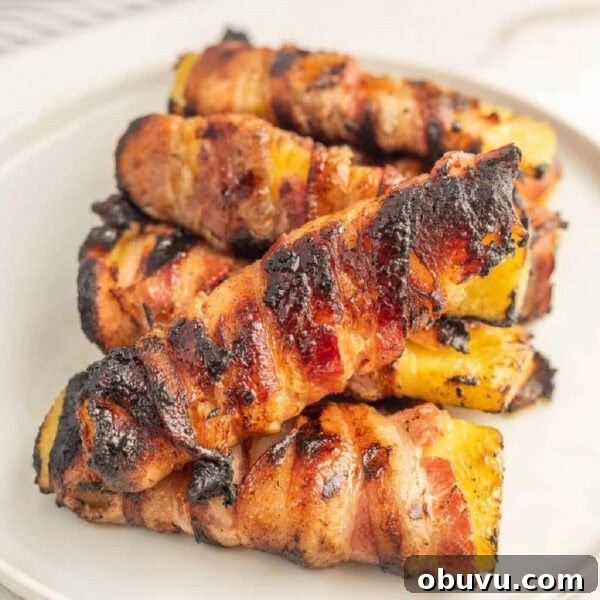 Smoky Grilled Jalapeño Poppers with Cream Cheese Filling 11 Grilled bacon-wrapped chicken thighs with charred grill marks on a white plate
