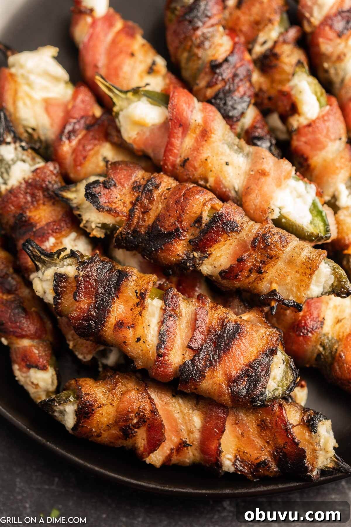 Smoky Grilled Jalapeño Poppers with Cream Cheese Filling 8 Close up image of bacon wrapped jalapeno poppers on a plate