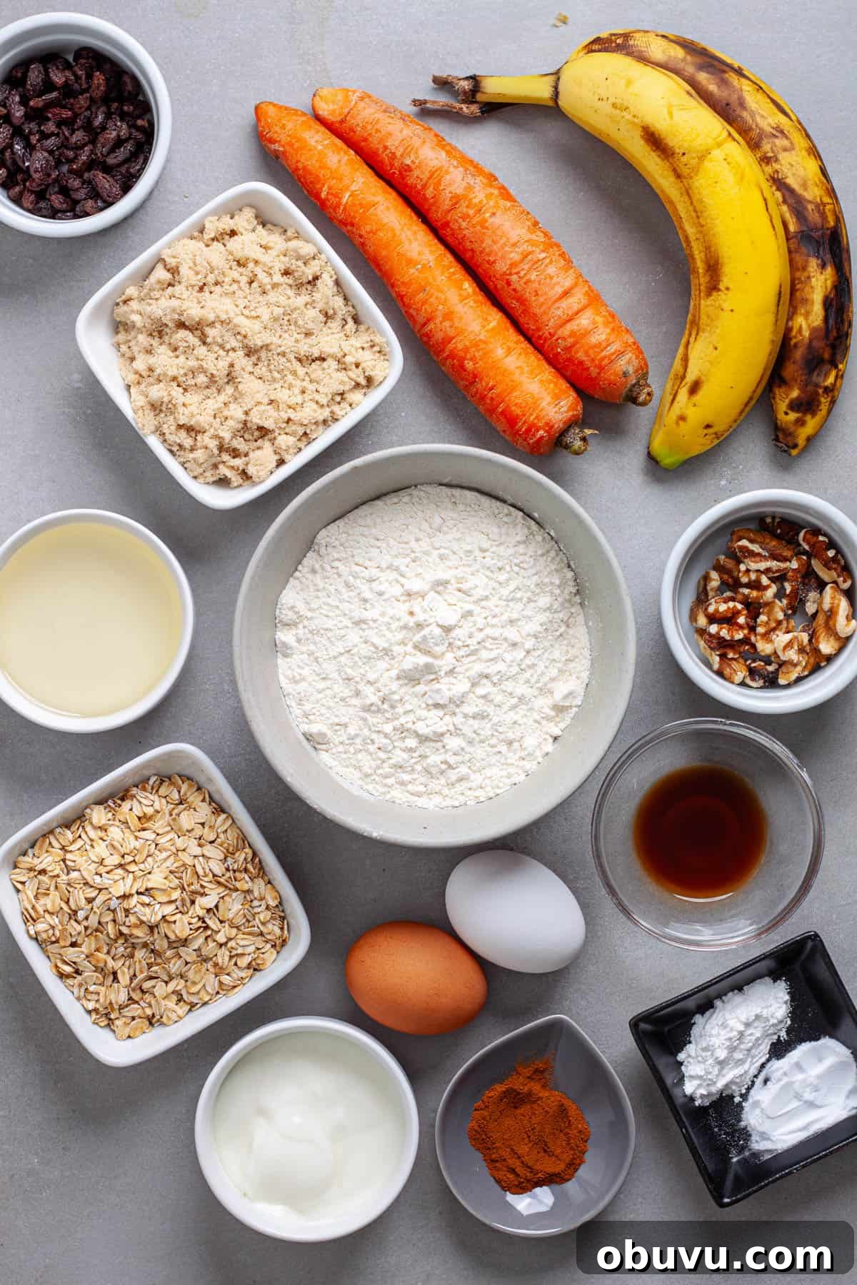 Ingredients for banana carrot muffins on a gray table.