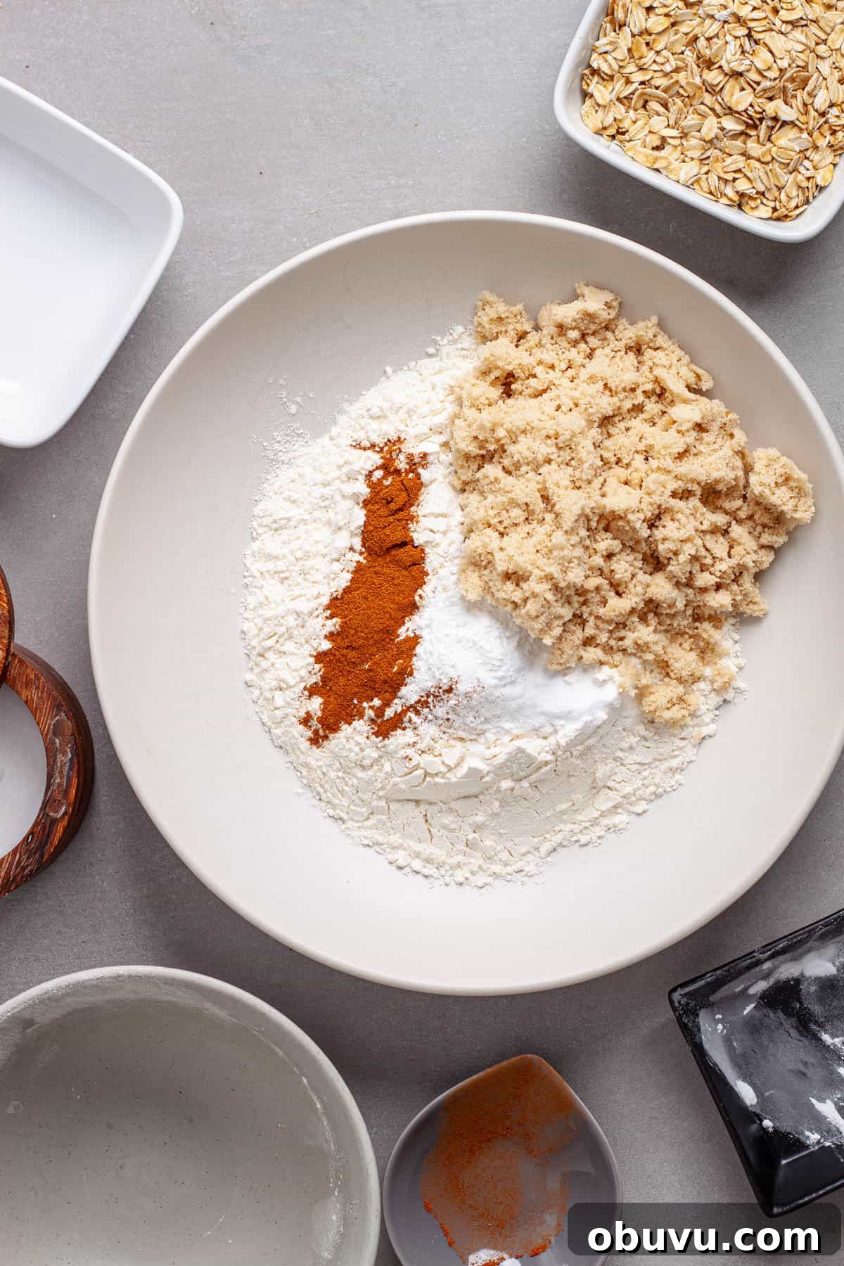 Dry ingredients for carrot and banana muffins added to a mixing bowl.