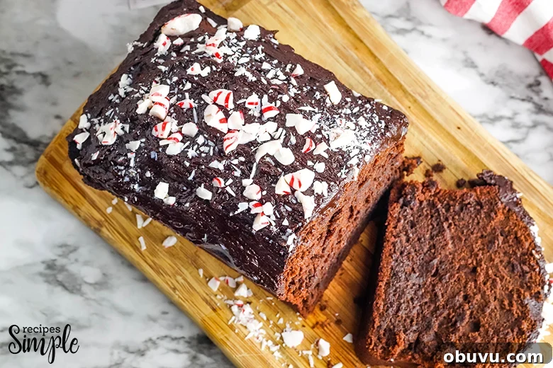 Chocolate Peppermint Pound Cake Recipe — Festive Holiday Dessert 3 Peppermint Chocolate Pound Cake with crushed peppermint candy on top on wooden serving board