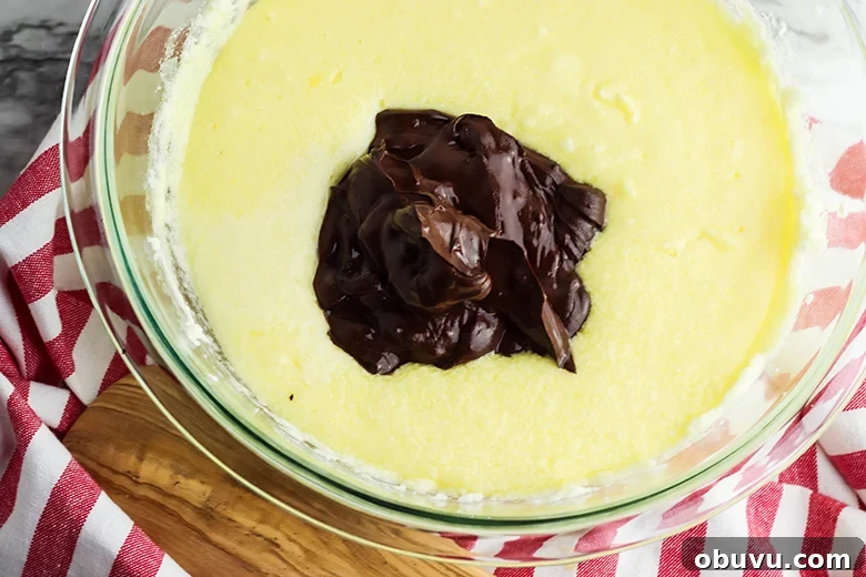 Chocolate Peppermint Pound Cake Recipe — Festive Holiday Dessert 7 Adding chocolate mixture and peppermint extract in glass bowl