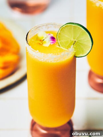 Mangorita (Frozen Mango Margarita) in a glass garnished with lime.
