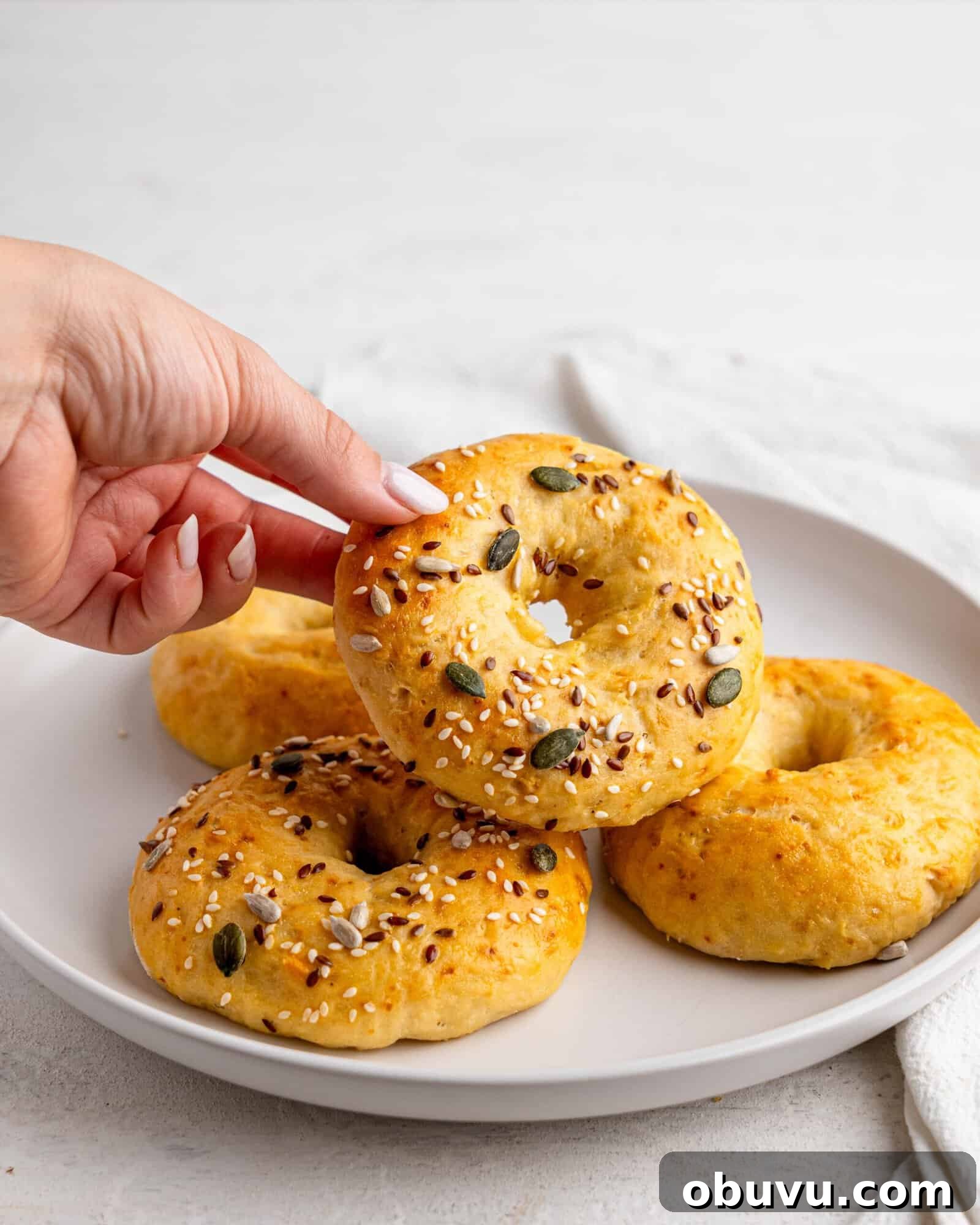 3-Ingredient Bagels Ready in 30 Minutes (No Rise) 2 Four easy bagels on a white plate.