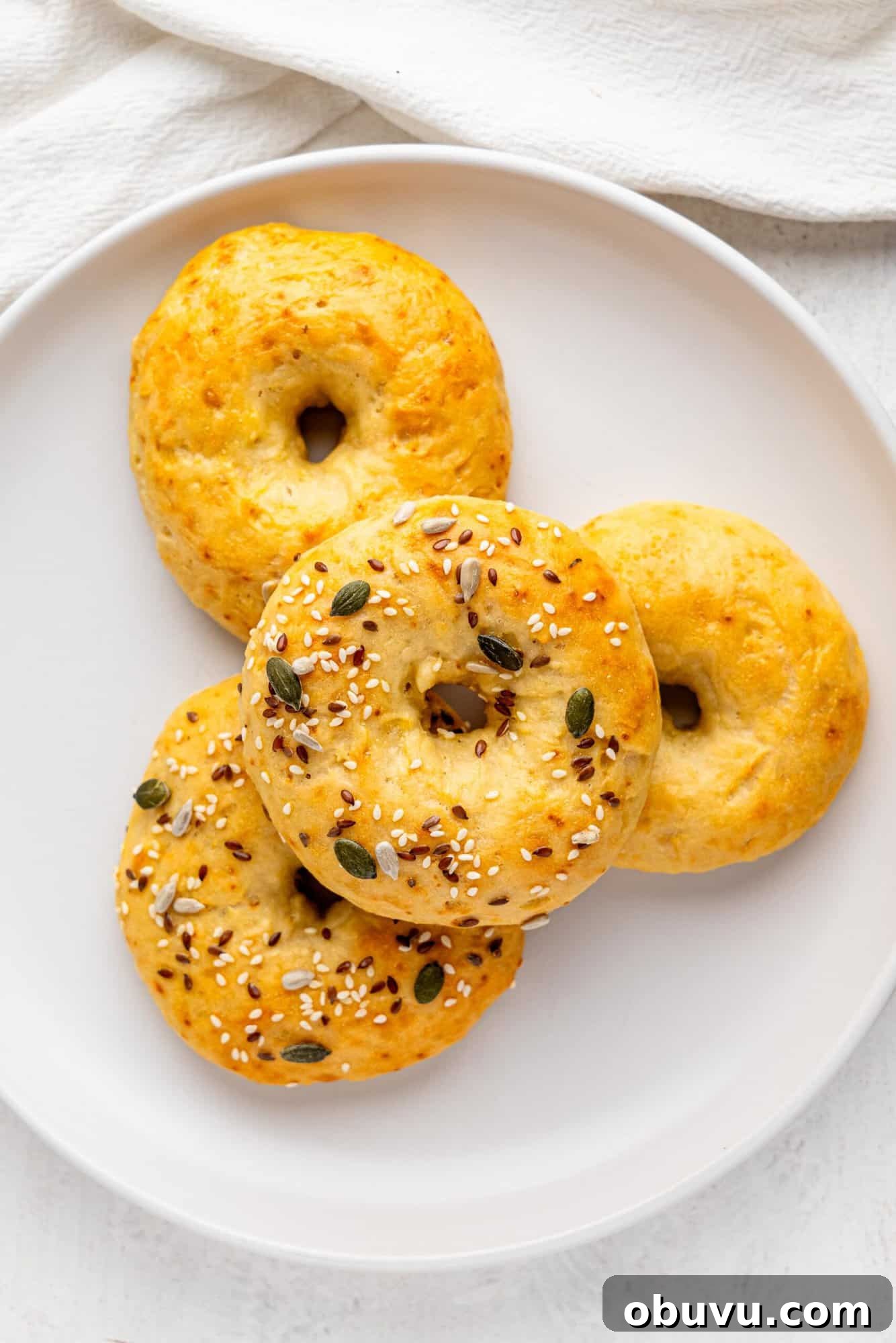 3-Ingredient Bagels Ready in 30 Minutes (No Rise) 4 Bird's eye view of 3 ingredient bagels on a white plate.