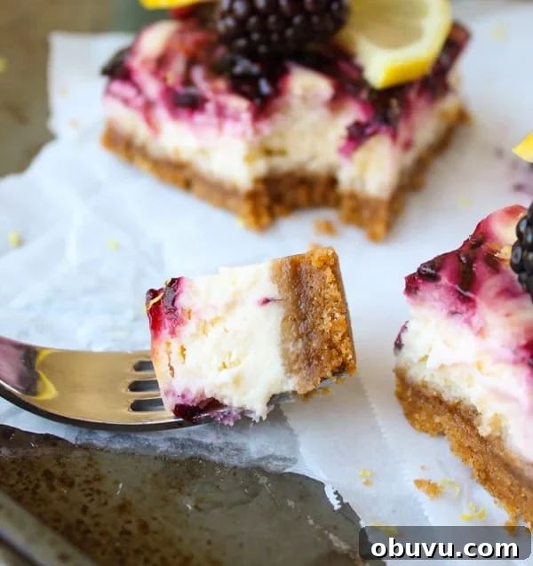 Lemon and Blackberry Dessert Bars: Zesty Summer Fruit Bars 4 blackberry lemon cheesecake bars on parchment paper with a bite on a fork.