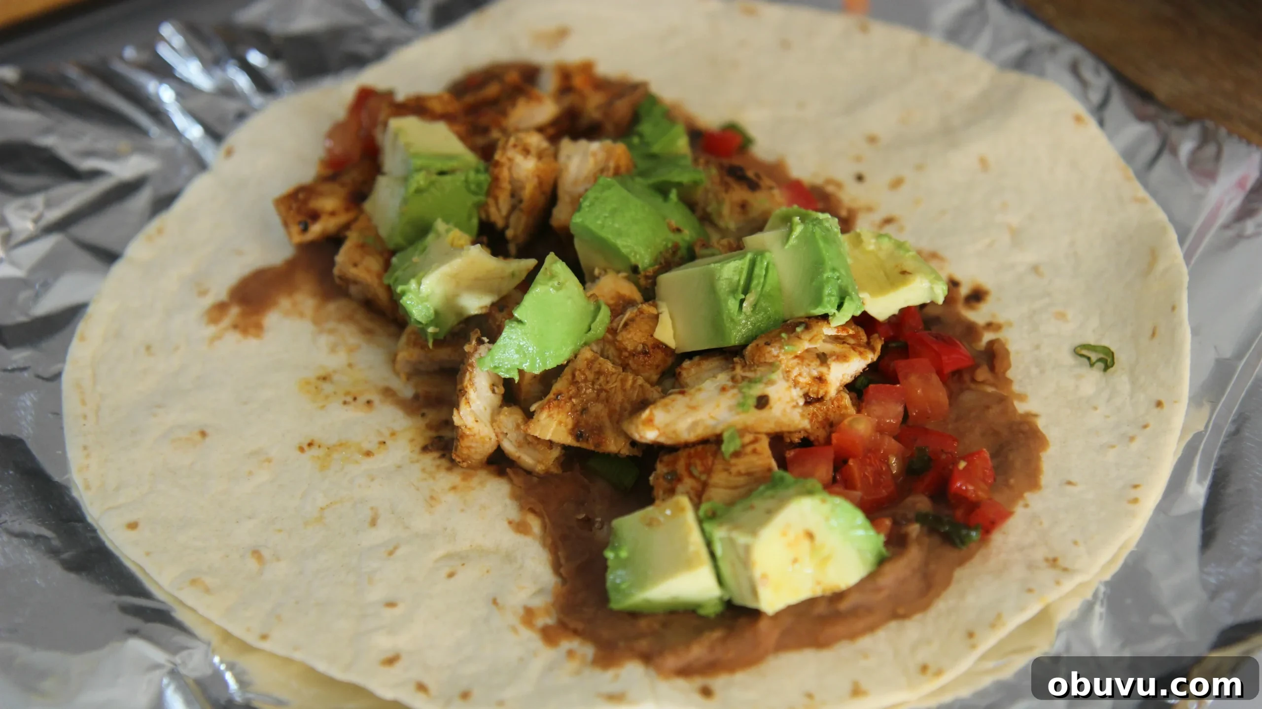 Tex-Mex Grilled Chicken Burrito Recipe: Flavorful Weeknight Meal 6 Add the chicken to a tortilla with refried beans, avocado chunks and some tomatoes.
