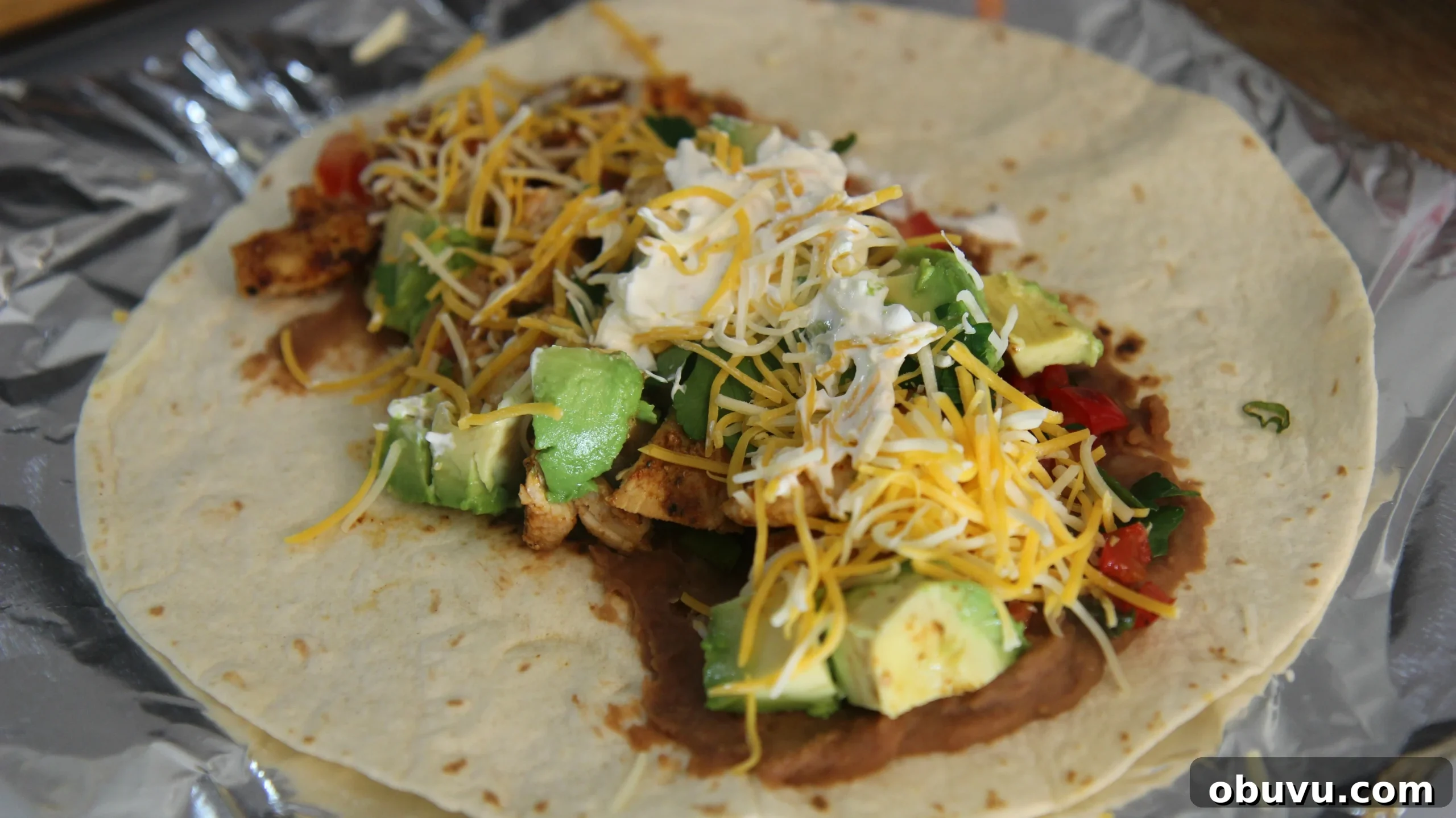 Tex-Mex Grilled Chicken Burrito Recipe: Flavorful Weeknight Meal 7 Top this tex-mex burrito with cheese and sour cream.
