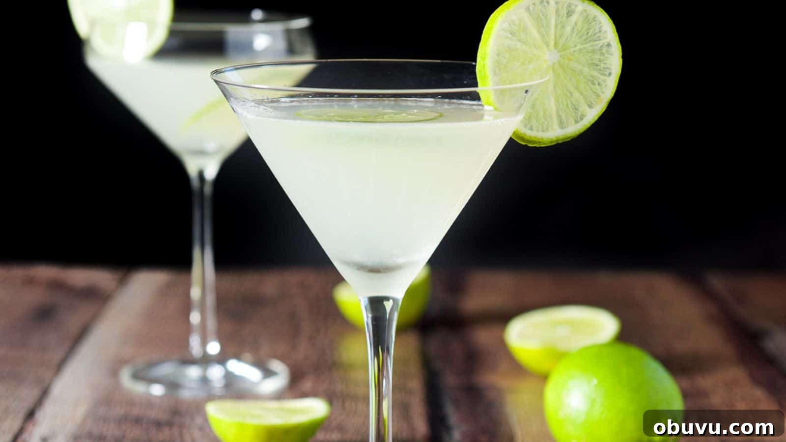 Classic Kamikaze Cocktail Recipe and Serving Tips 3 Two martini glasses filled with the lime drink with lime wheels on the rim and limes on the table