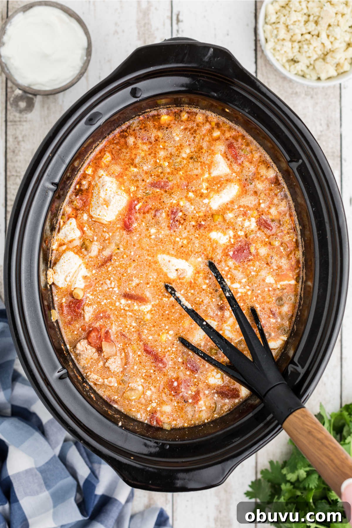 Cream cheese added to a slow cooker buffalo chicken chili recipe.
