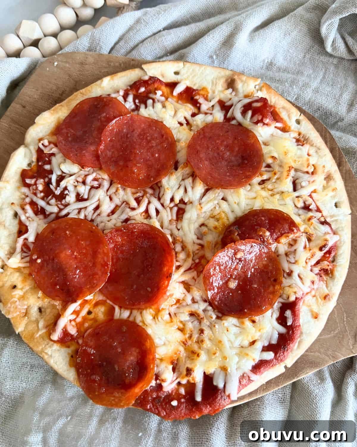 Air fryer pepperoni pita pizzas on a wooden cutting board. 