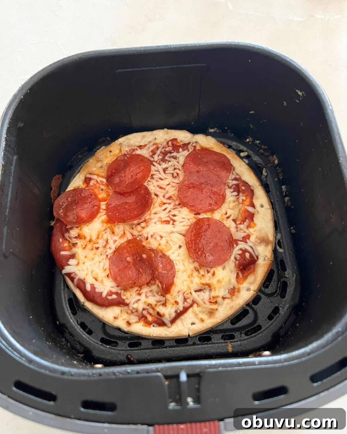 Mini pita pizzas finished in air fryer basket. 