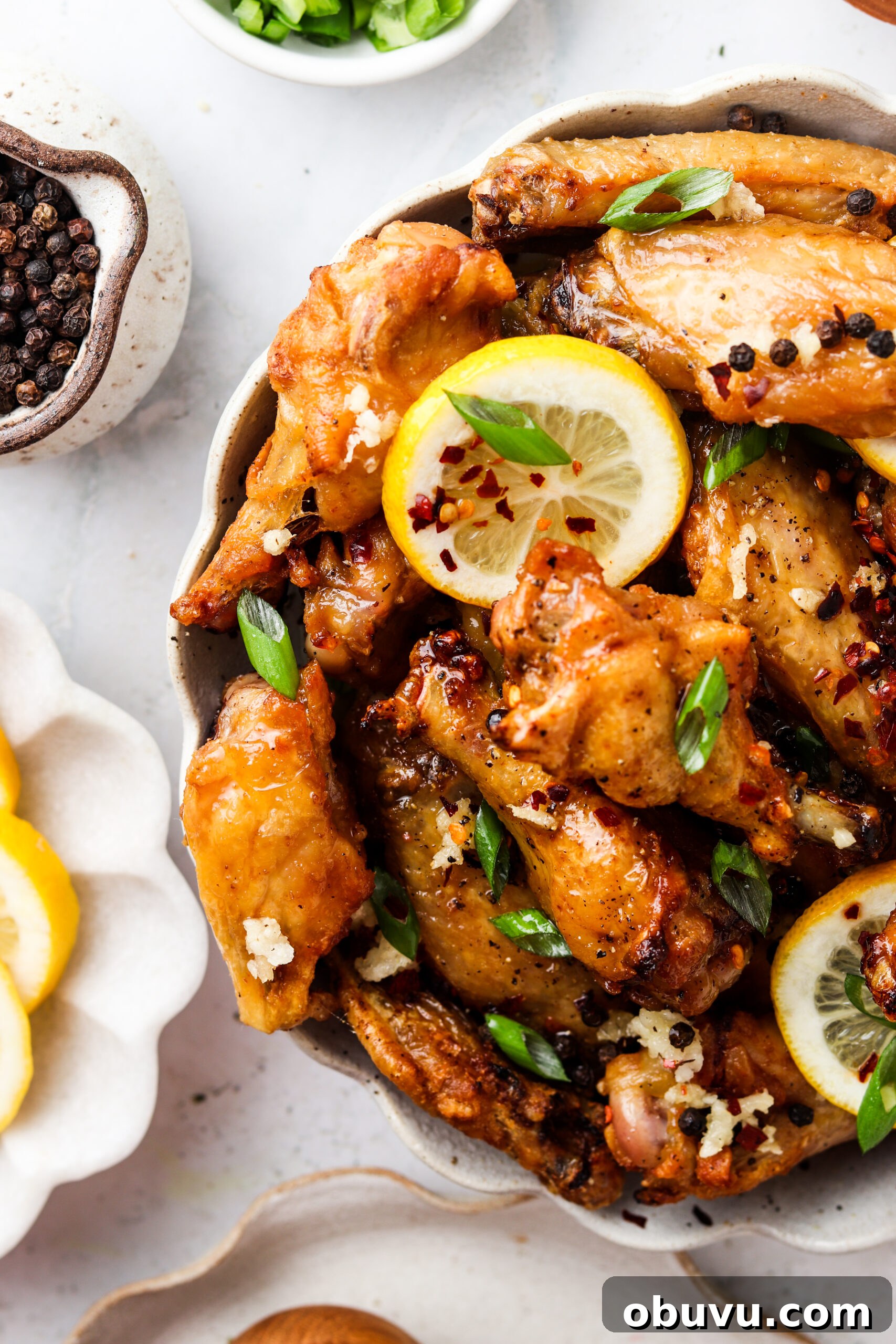 honey lemon pepper wings 3 Honey lemon chicken wings in a bowl with green onions.