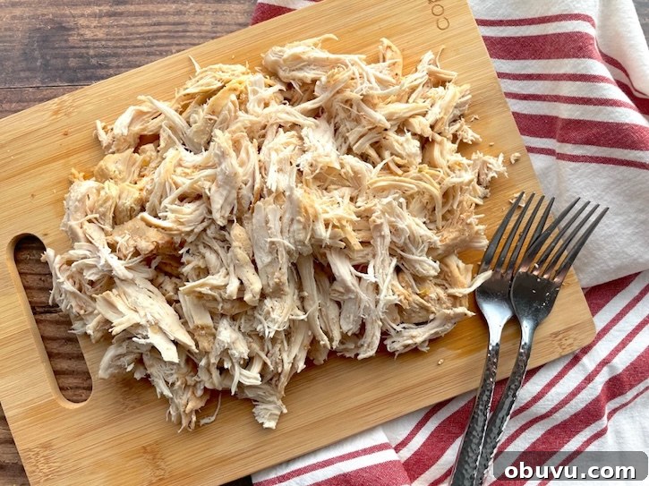Creamy Chicken Taco Soup Recipe for Cozy Weeknight Dinners 7 Shredded chicken breasts on a cutting board with forks.