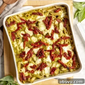 Salmon Pesto Pasta Recipe: Creamy 20-Minute Meal 14 Top down view of white, square casserole dish with pesto pasta topped with sun-dried tomatoes and mozzarella