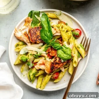 Salmon Pesto Pasta Recipe: Creamy 20-Minute Meal 16 A plate of salmon pesto pasta next to a large pan of salmon pesto pasta.