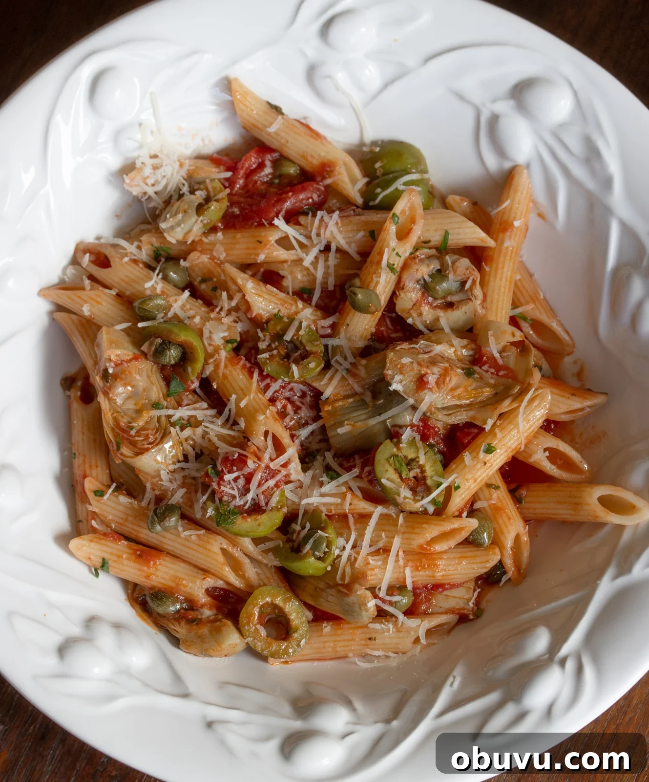 Sun-Dried Tomato Penne with Olives & Artichokes 7 penne pasta with tomatoes sauce served in a white dish
