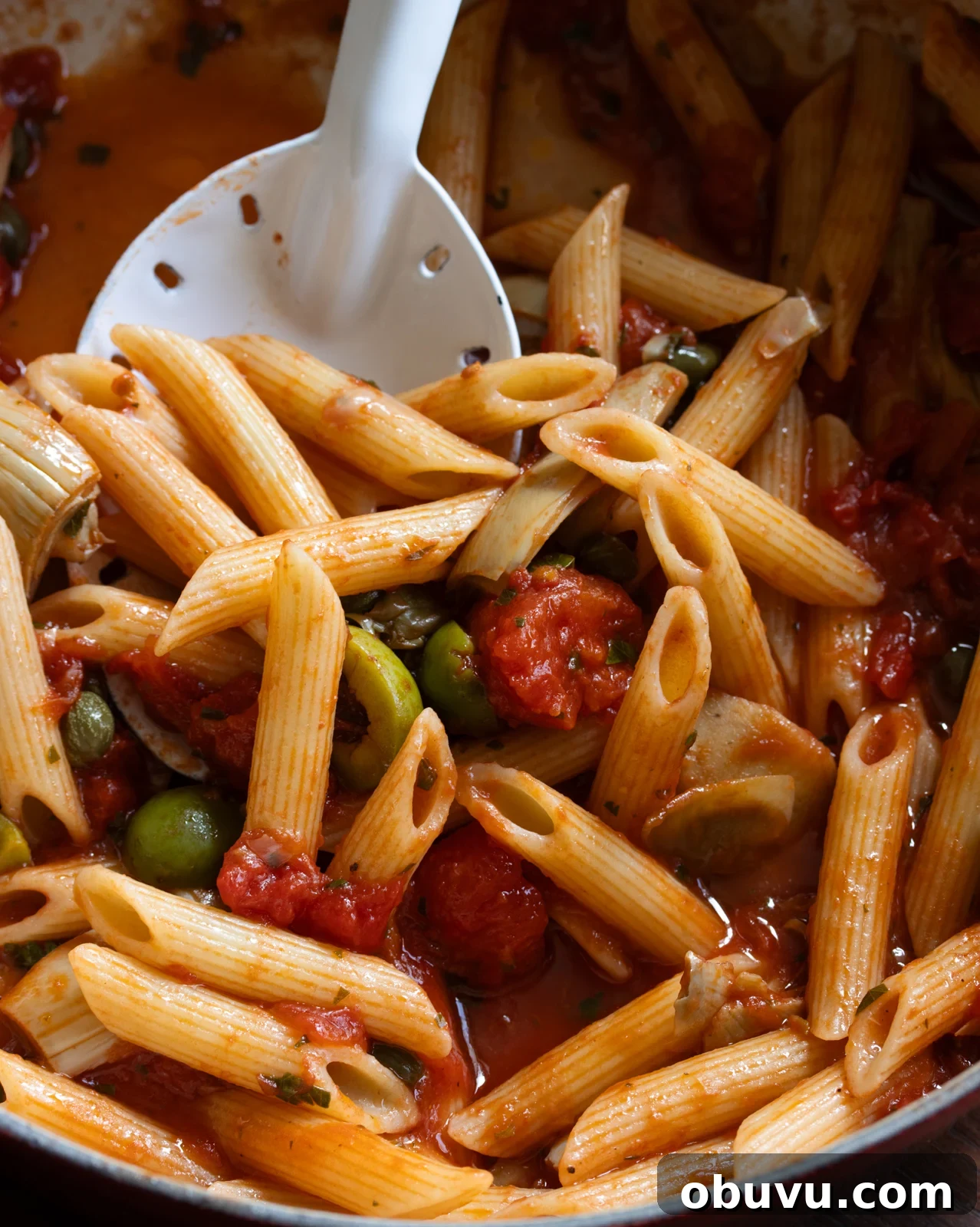Sun-Dried Tomato Penne with Olives & Artichokes 8 pan with the pasta and a serving spoon