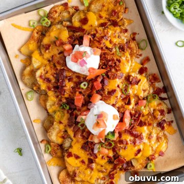 Loaded Potato Nachos with Cheese, Jalapeño & Sour Cream 5 A sheet pan of crispy potato nachos.