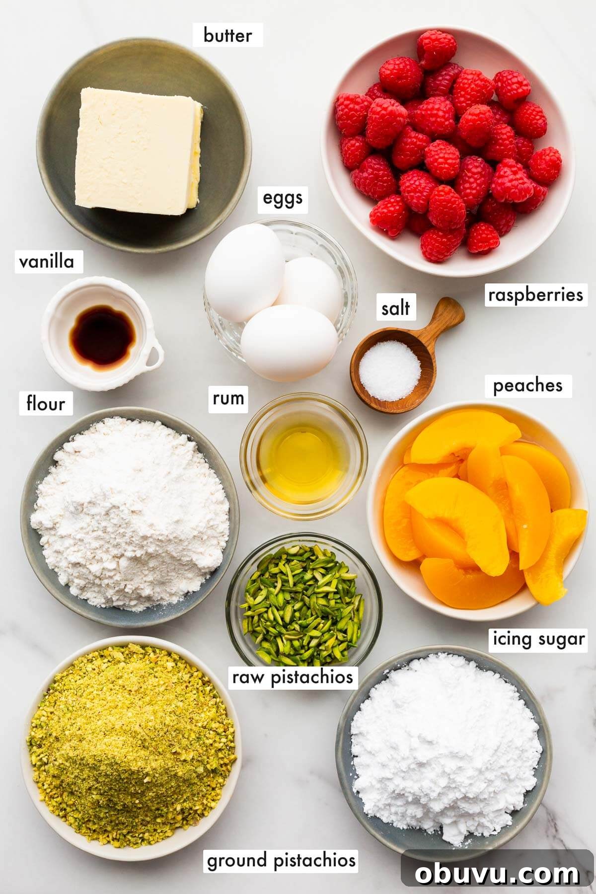Ingredients to make a pistachio tart from scratch topped with peaches and raspberries.