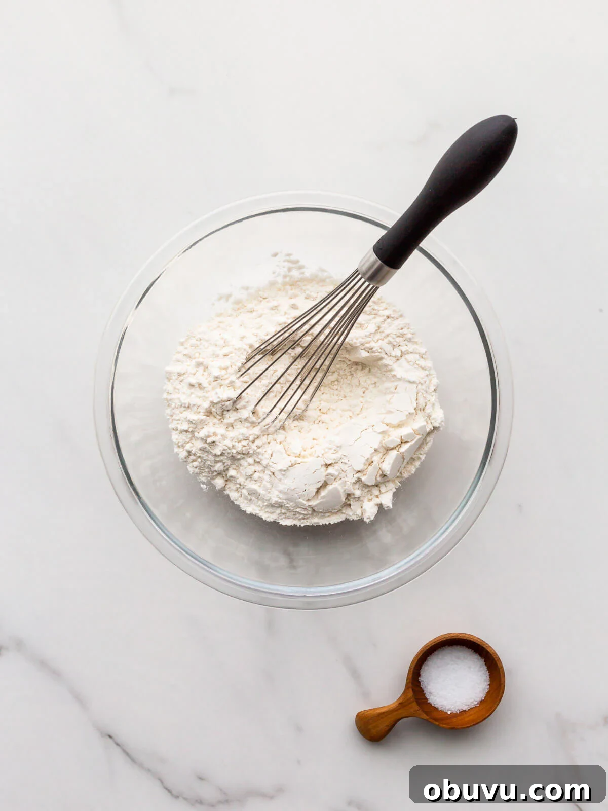 Whisking flour and salt in a small bowl to make a pistachio tart crust.