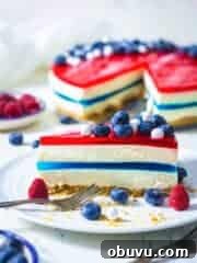 A slice of fresh cake showing off the blue middle layer and the red top with berries.