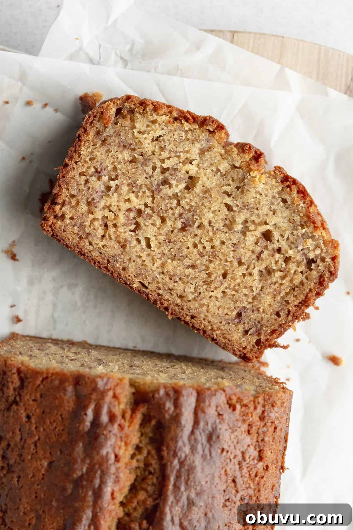 Moist Banana Bread Without Gluten — Simple Recipe for Tasty Loaf 9 A slice of gf banana bread on parchment paper.