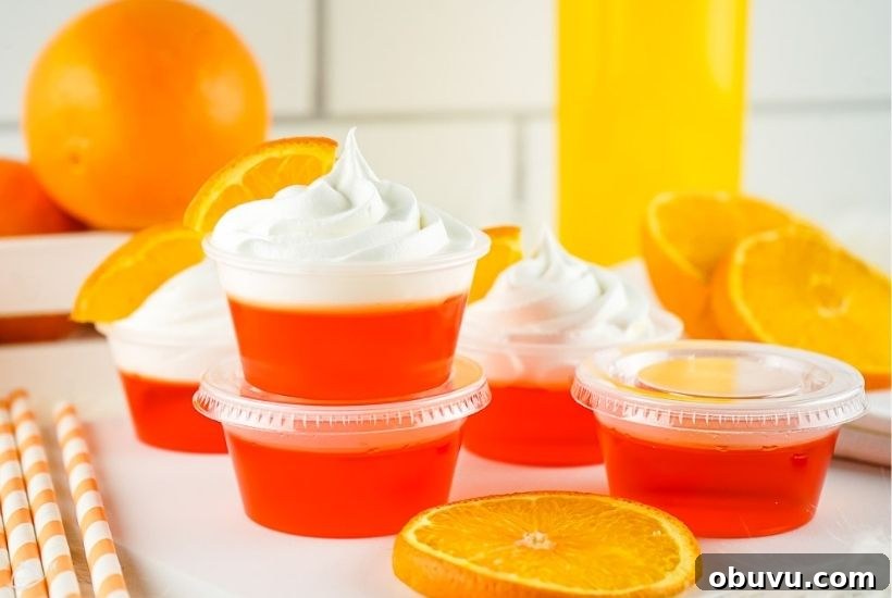 Mimosa Jello Shots Recipe: Sparkling Champagne Party Treat 7 several mimosa jello shots with whipped cream next to oranges