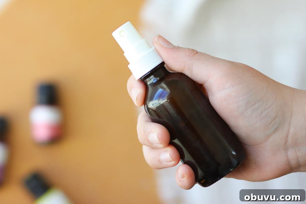 10 DIY Essential Oil Air Freshener Sprays for Every Room 4 a small glass amber spray bottle with essential oils on the table behind it
