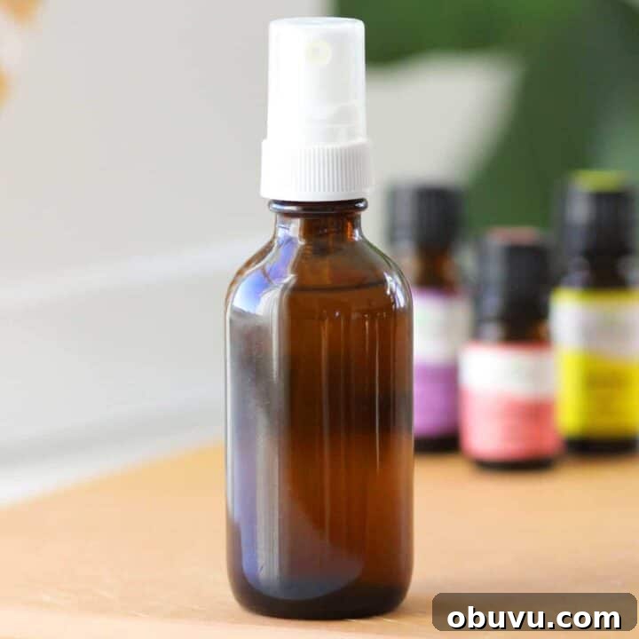 a small glass amber spray bottle with essential oils on the table behind it