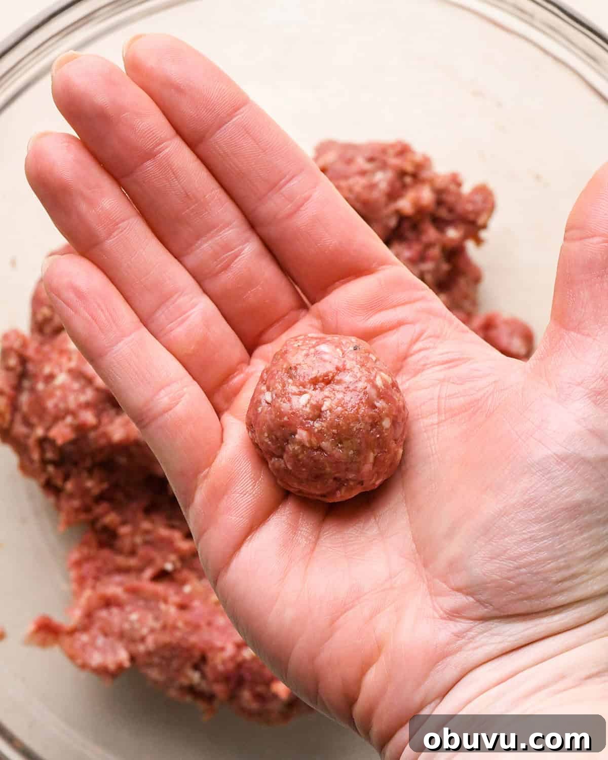 Gluten-Free Italian Meatballs Recipe – Tender & Flavorful 12 a hand rolling a gluten free meatball into a ball