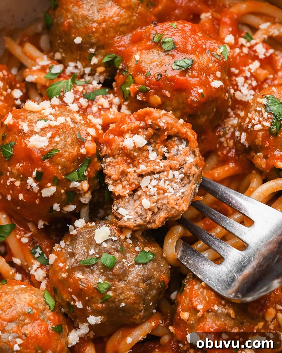 Gluten-Free Italian Meatballs Recipe – Tender & Flavorful 17 a fork with half of a Gluten Free Meatball on it in marinara sauce