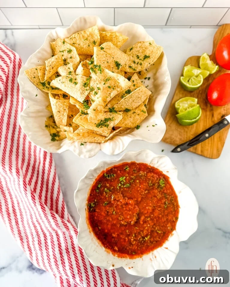 Food processor salsa in a serving bowl next to a basket filled with corn tortilla chips.